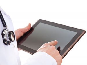 A doctor looks at a tablet. 